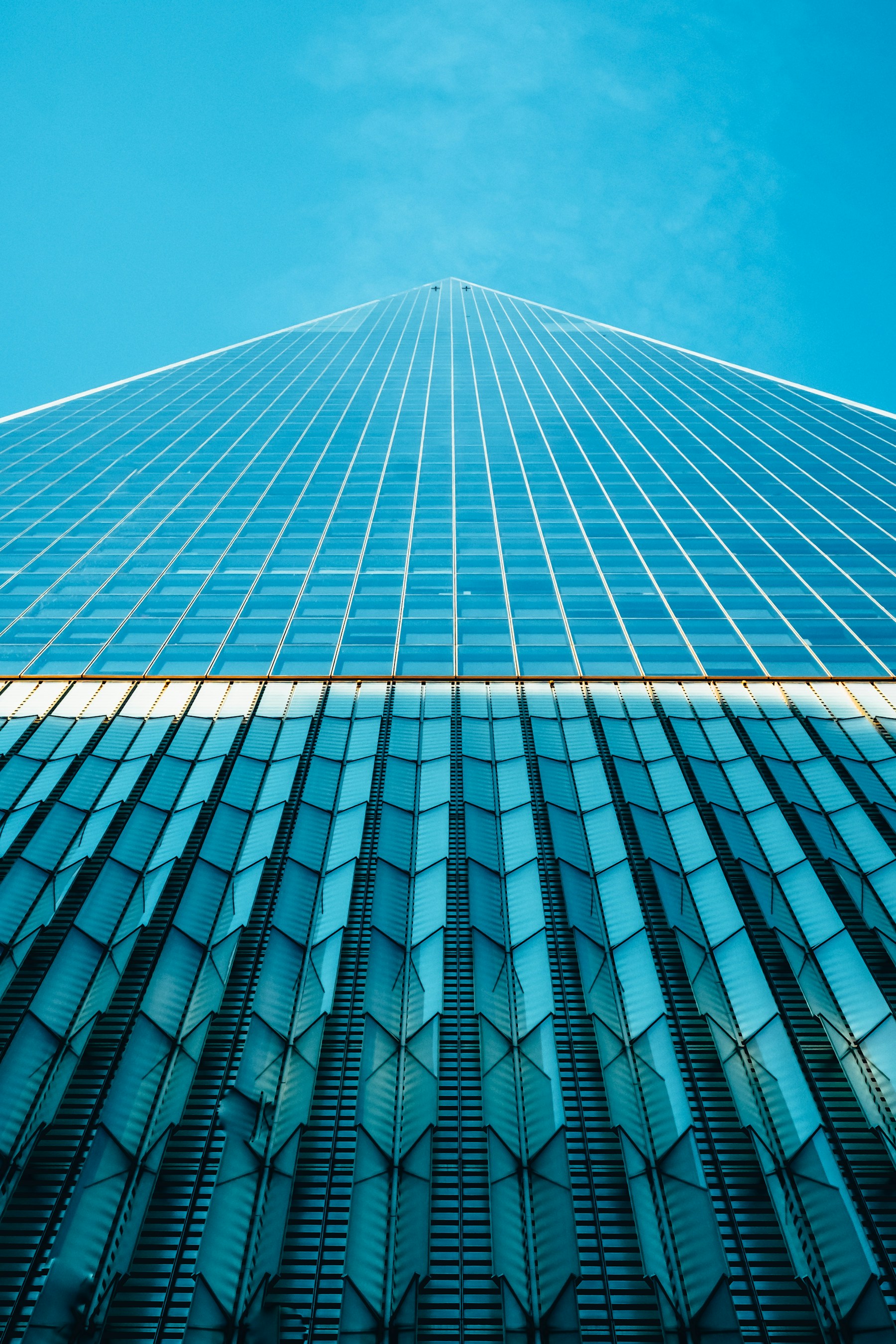 Looking up at the geometric glass facade of a London building